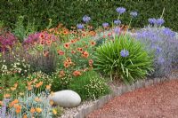 Eryngium, Agapanthus, Yucca, Phormium, Penstemon, Crocosmia in borders - Mediterranean Garden, Barnsdale Gardens