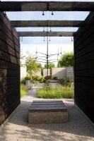 Timber and concrete seat under wooden pergola in modern garden