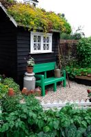 Garden potting shed with living roof and weather vane