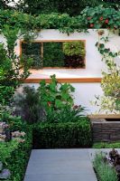 Scented herbs in vertical wall boxes in small contemporary garden
