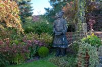 Oriental statue in autumn garden - Rosemary and Rainer Bischoff Garden, Berlin