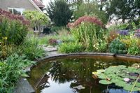 Circular pond in autumnal garden - Karl Foerster Garden Potsdam Bornim, Germany 