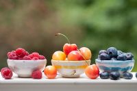 Summer fruits in bowls - Blueberries, raspberries and Rainier cherries
