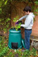Filling the compost bin with garden refuse