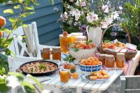 Table laden with food and dishes made from Apricots. Lavatera in vase 
