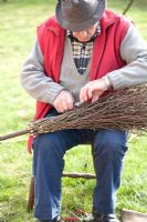 Making a Birch broom - man tying up birch branches with steel wire