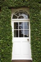 Trained Pyracantha neatly edges front door - Pine House