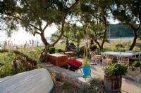 Patio in Mediterranean coastal garden with old fishing boat