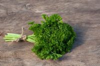 Bunch of Parsley on wooden surface