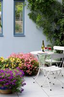 Summer containers on patio with table and bottle of wine