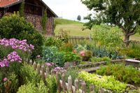 A typical German farmer's garden, flowers and vegetables are mixed and surrounded by a wooden fence - Buxus, Cosmos, Endivies, Carrots, Cucurbita, Allium porrum, Malus domestica, Tagetes and Zinnia