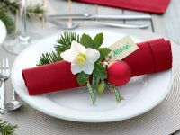 Place setting decoration with Hellebore flower, fir foliage and baubles