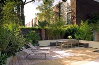 Small urban garden with decked relaxing area and loungers, London