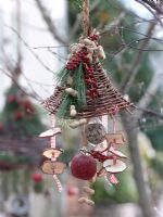 Decorative bird feeding station with seed cakes, apples and fir cones