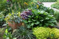 Hosta and Origanum majorana 'Aureum' in Spring border, Heuchera in terracotta pot - Imig-Gerold Garden