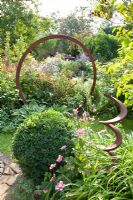 Metal ring and spiral used as decoration in flowerbed - Marx Garden