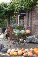 Metal table and chairs on patio decorated with Pumpkins - Huys en Hof 

