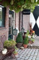 Entrance to house with containers and pots on cobbles - Huys en Hof 