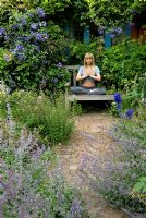 Woman practising yoga on garden bench