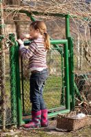 Girl entering a garden gate