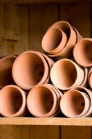 Storing empty terracotta pots on a shelf in the potting shed