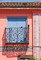 Iron balcony and blue doors in the Spanish Garden at The Roof Gardens, Kensington