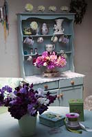 Old dresser in the flower studio with collection of vintage vases, Dahlia arrangement, freshly picked Sweet Peas, ribbons and pins - Green and Gorgeous
