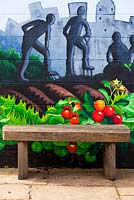 Urban spaces garden mural and wooden bench at Ryton Organic gardens, Warwickshire