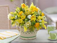 Yellow and white scented bouquet with Tulipa - tulips, Ranunculus - buttercups, Acacia - mimosa, Hyacinthus - Hyacinths and branches of Vaccinium - blueberry
