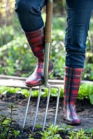 Woman in red wellies with stainless garden fork 