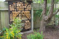 Insect house attached to fence in secluded area of garden at Forest Road, Meols, Wirral. The garden is open for The National Garden Scheme.