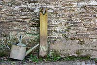 Watering can next to water tap in the Lost gardens of Heligan, Cornwall, England