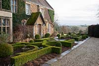 Parterre and lolipop trees in front of house - Broughton Grange, Oxfordshire 