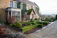 Parterre and lolipop trees in front of house - Broughton Grange, Oxfordshire 