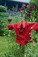 Garden scarecrow for Remembrance day surrounded by purple Papaver somniferum - Opium Poppies