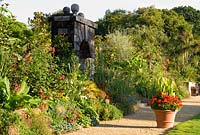 Exotic planting in the Collector Earl's Garden, designed by Julian and Isabel Bannerman, includes echiums, monardas, salvias, eryngiums and rudbeckias. Large terracotta pots punctuate the path planted with red pelargoniums and cannas. 