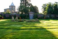 A grass maze with central stones occupies the centre of the Collector Earl's Garden, designed by Julian and Isabel Bannerman, with the Fitzalan Chapel seen beyond.