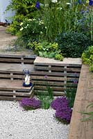 A garden for a young couple with a budget of £7000. Reclaimed scaffold boards and split logs predominate - 'Our First Home, Our First Garden' - Gold medal winner - RHS Hampton Court Flower Show 2012