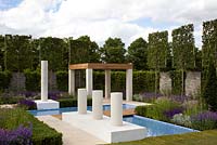 Italian inspired geometric design. T-shaped water feature and pleached Carpinus - Hornbeams. Natural limestone pavers and four Chilstone cylindrical sculptures - 'The Italian Job' - Silver Gilt medal winner - RHS Hampton Court Flower Show 2012 