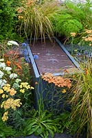 Water feature softened with planting of Eryngium, Achilleas and grasses - 'The Landform Garden' - Gold medal winner and Best Summer Garden - RHS Hampton Court Flower Show 2012 
