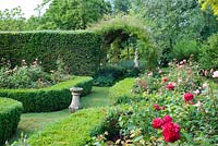 Formal rose garden with sundial and statue