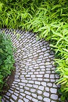 Path made with granite oval stones, edged with bamboo