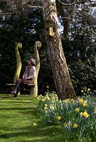 Christine Skelmersdale owner of Broadleigh Gardens Bulbs in her garden at Barr House. In foreground masses of naturalized Narcissus 'W.P. Milner'