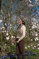 Christine Skelmersdale owner of Broadleigh Bulbs in her garden by the Magnolia lobneri and underneath a spread of Anemone blanda