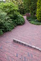 Brick path and group of deciduous shrubs