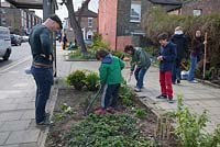 Adults and children working at the Edible Bus Stop