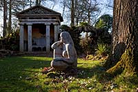 'Goddess of the Woods' sculpture and one of the two green oak temples in the Stumpery, Highgove Garden, February 2011. 