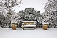 Stone bench and two pots covered in snow, Highgrove Garden, January 2010. 