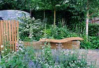 Undulating timber bench in raised bed, with extensive perennial planting - A Celebration of Caravanning Garden, Chelsea 2012
