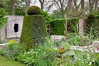 Topiary and flowerbeds in country garden 